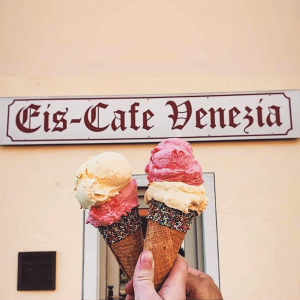 Zwei Eistüten vor dem Eiscafe Venezia Schild in Marktoberdorf.